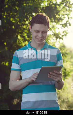 trendy guy using a tablet pc outdoors Stock Photo