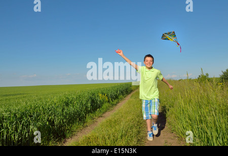 boy playing with kite on greenfield Stock Photo