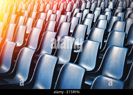 Empty plastic chairs at the stadium, with toning effect Stock Photo