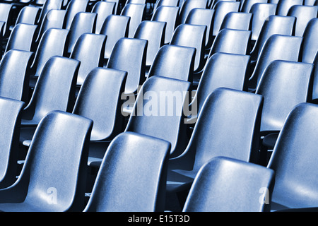 Empty plastic chairs at the stadium, with toning effect Stock Photo