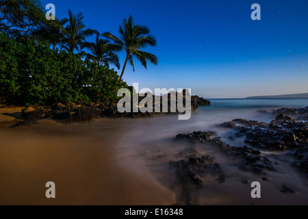 The Moon glowing over Secret Beach in Maui. Stock Photo