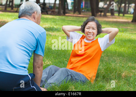 smiling senior grandmother doing sit-ups in the park Stock Photo