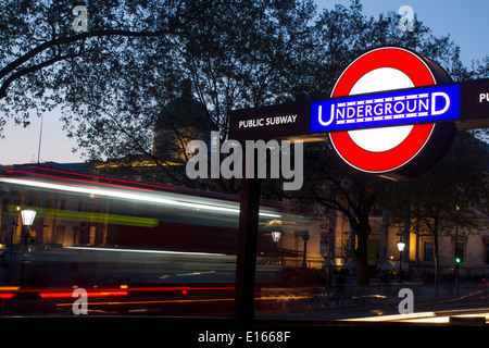 Trafalgar Square Underground station sign with dome of National Gallery and busy traffic on road behind London England UK Stock Photo