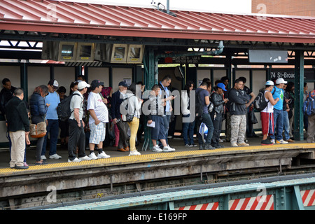 Commuters, many with cell phones, on the 74th Street platform of the #7 subway train in Jackson Heights, Queens, New York Stock Photo