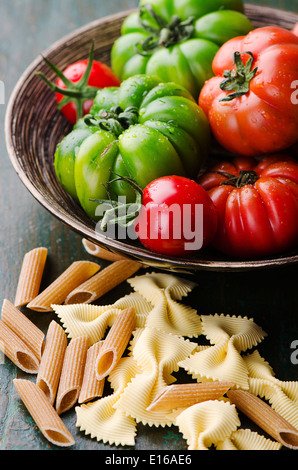 Fresh green and red tomatoes with mixed pasta Stock Photo