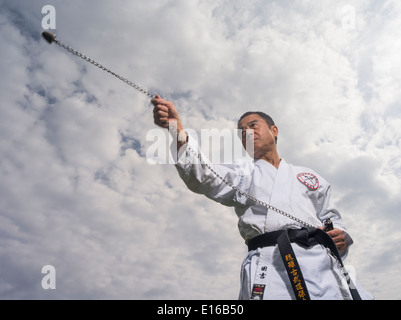 Karate & Kobudo Master Yukio Kuniyoshi. Kaicho of Ryukyu Kobudo Hozon Shinko Kai. Training on Okinawa, Japan with ball and chain Stock Photo