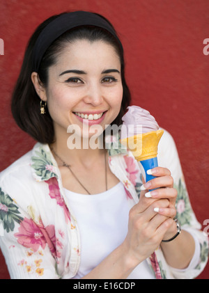 Woman (model released) eating Purple Potato Ice cream by Blue Seal on Kokusai Street, Naha, Okinawa Stock Photo