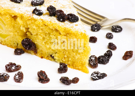 Apple vanilla ginger cake with black currants on white plate and silver fork Stock Photo