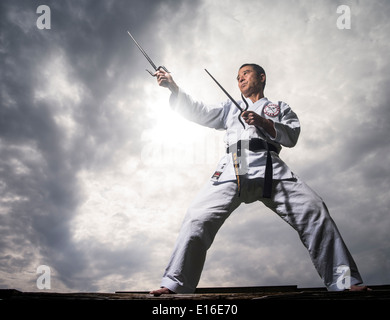 Karate & Kobudo Master Yukio Kuniyoshi. Kaicho of Ryukyu Kobudo Hozon Shinko Kai. Training on Okinawa, Japan with manji sai. Stock Photo