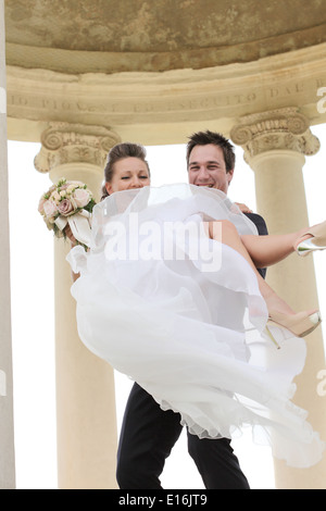 Groom carrying bride Stock Photo