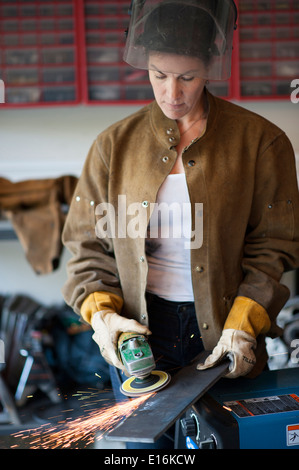 Female welder at work in her garage Stock Photo