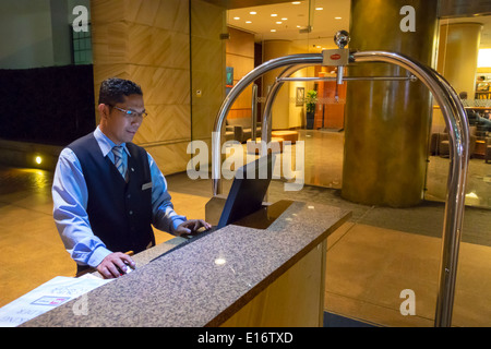 Sydney Australia,Sussex Street,Four Points by Sheraton Darling Harbour,hotel,lobby,Asian man men male,bellman,bellhop,service,using,computer,AU1403112 Stock Photo