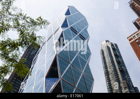 The Hearst Tower in New York between other skyscrapers with blue sky Stock Photo