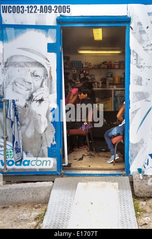 Hairdressing, people at improvised hair salon and barber shop in container, Imizamo Yethu Township (Mandela Park) settlement, Cape Town, South Africa Stock Photo