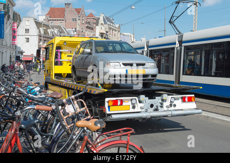 Tow Truck urban towing away a wrongly parked car in Amsterdam. Stock Photo