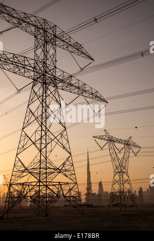 Electricity transmission lines and pylons and skyline at dusk in Dubai United Arab Emirates Stock Photo