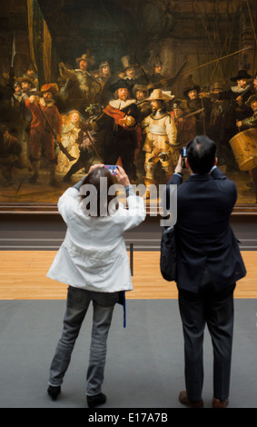 Visitors to the Rijksmuseum in Amsterdam, the Netherlands, taking photos of Rembrandt's The Night Watch Stock Photo