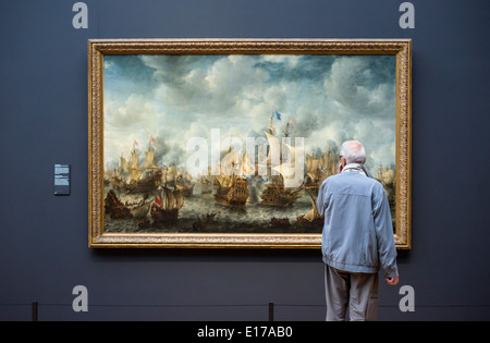 Man looking at The Battle of Terheide by Jan Abrahamsz Beerstraten in the Rijksmuseum, Amsterdam, the Netherlands. Stock Photo