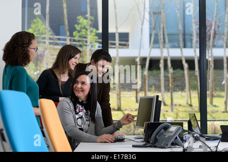 Office workers discussing a project while looking at a computer screen Stock Photo