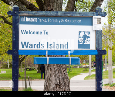 Welcome to Wards Island sign at the ferry dock on Wards Island with Coyote warning sign in corner. Stock Photo