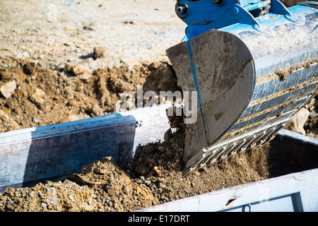 Closeup of dump truck being filled by excavator Stock Photo