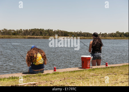 Two girls fishing on the Crystal Springs River from the Fort Island Park in Crystal Springs, Florida USA Stock Photo