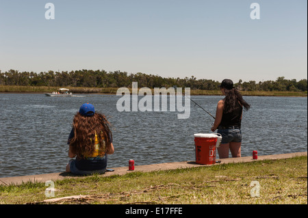 Two girls fishing on the Crystal Springs River from the Fort Island Park in Crystal Springs, Florida USA Stock Photo