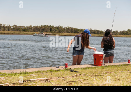 Two girls fishing on the Crystal Springs River from the Fort Island Park in Crystal Springs, Florida USA Stock Photo