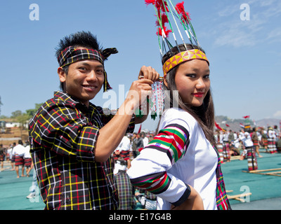 Ethnic Kachin male in traditional attire wear traditional rattan hats with  boar fangs and girls in white headdresses during a national cultural show  Stock Photo - Alamy