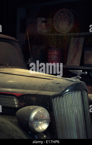 A dusty old Packard sits in a garage. Stock Photo