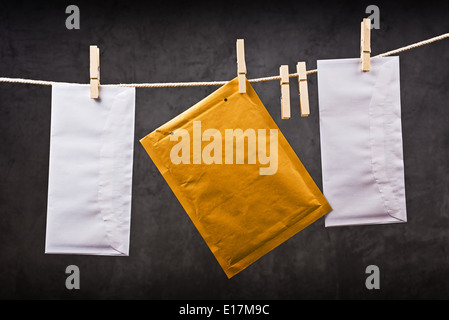 Three Postal mail Envelope hanging on rope attached with clothes pins. Communication concept. Stock Photo