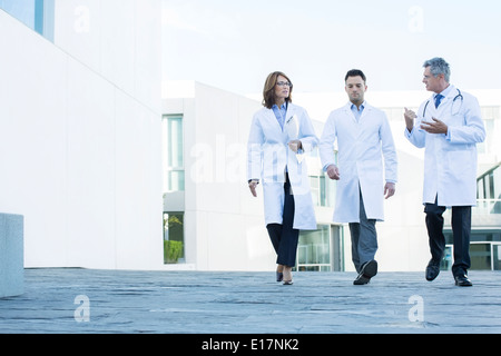 Doctors walking and talking on roof Stock Photo