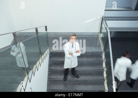 Portrait of confident doctor on staircase Stock Photo