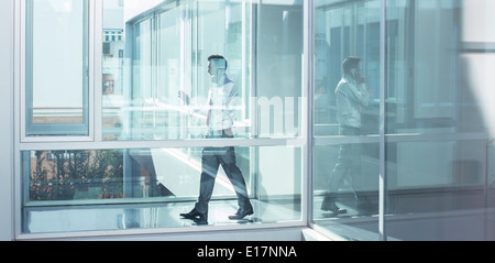 Businessman talking on cell phone in office corridor Stock Photo