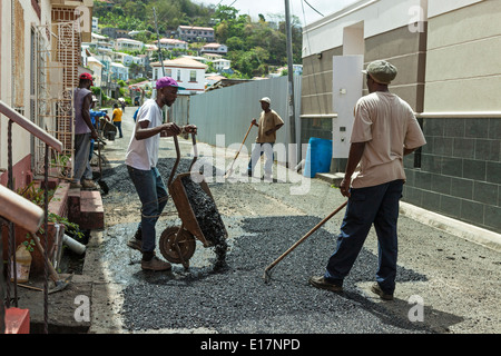 Workmen repairing a road, using tar and handheld tools, in St George, Grenada, East Indies Stock Photo