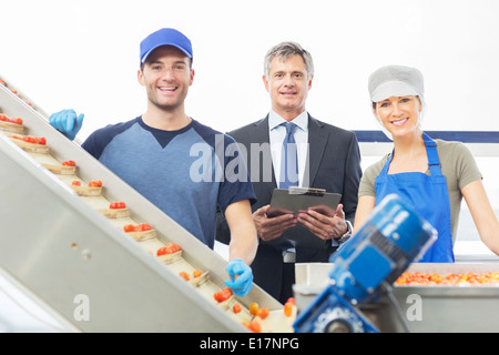 Portrait of supervisor and workers in food processing plant Stock Photo