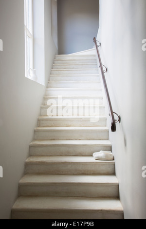 Slippers on whitewashed staircase Stock Photo