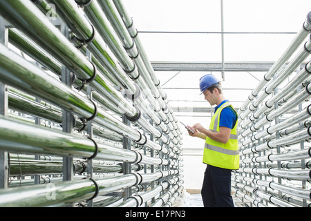 Male engineer using digital tablet while standing in front of wind ...