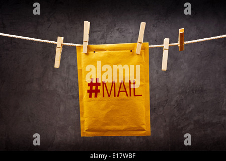Predictive shipping concept. Postal mail Envelope with hash tag hanging on rope attached with clothes pins. Stock Photo