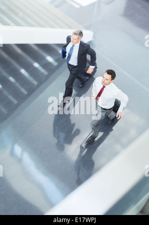 Businessmen with suitcases running in lobby Stock Photo