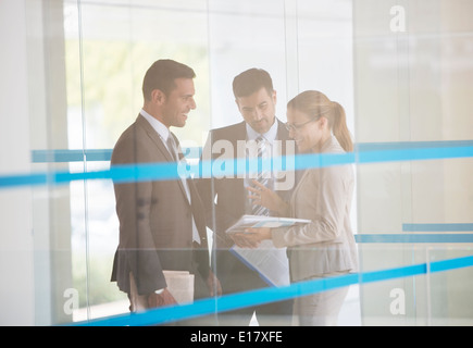 Business people discussing paperwork in corridor Stock Photo