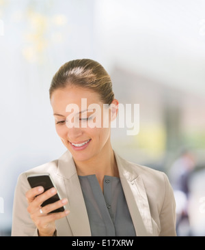 Businesswoman texting with cell phone outdoors Stock Photo