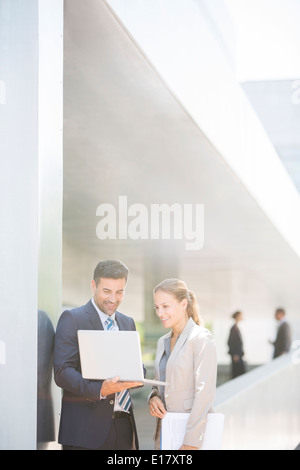 Business people using laptop outdoors Stock Photo