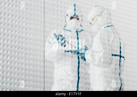 Scientists in clean suits working in laboratory Stock Photo