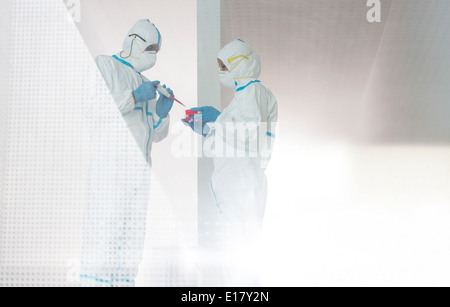 Scientists in clean suits working in laboratory Stock Photo