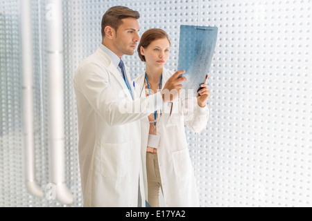 Doctors examining paperwork in hospital Stock Photo