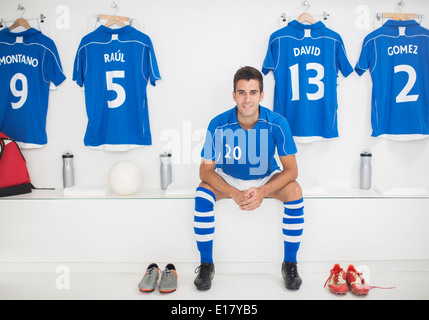 Soccer player sitting in locker room Stock Photo