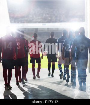 Silhouette of soccer players walking to field Stock Photo