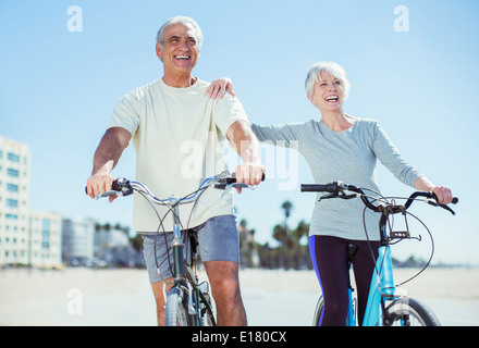 Senior couple with bicycles on beach Stock Photo