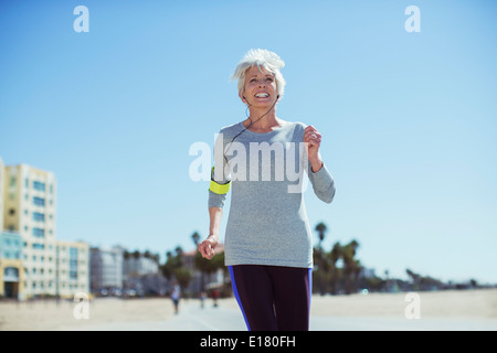 Senior woman power walking on beach Stock Photo